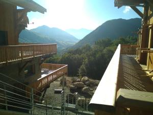 uma varanda de um edifício com montanhas ao fundo em Chalets Choseaux Lézami em Saint-Sorlin-dʼArves