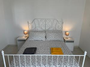 1 cama blanca con 2 mesitas de noche y 2 lámparas en La corte di Edo, en Porto Torres