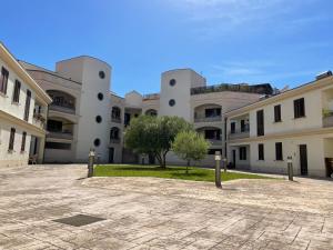 un gruppo di edifici con un albero al centro di La corte di Edo a Porto Torres