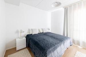 a white bedroom with a bed and a window at Apartment Sleepwell, Leppävaara, 71m2 with private sauna in Espoo