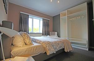 Un dormitorio con una cama grande y una ventana en - Charmante & chaleureuse maison -, en Waterloo