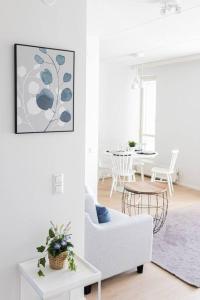 - un salon blanc avec un canapé blanc et une table dans l'établissement Apartment Sleepwell, Leppävaara, 71m2 with private sauna, à Espoo