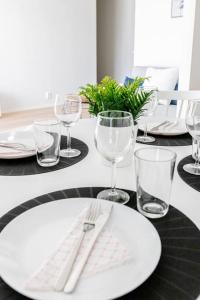 a table with a white plate and wine glasses at Apartment Sleepwell, Leppävaara, 71m2 with private sauna in Espoo