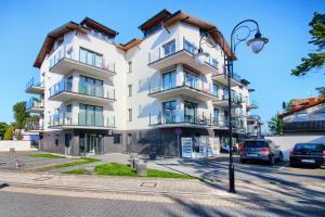 ミエルノにあるApartament Clipperの街灯のある通りにある大きな白い建物
