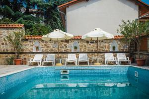 una piscina con 2 sombrillas y sillas en VILLA SOL, en Sunny Beach