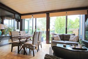 un porche cubierto con mesa, sillas y sofá en - Charmante & chaleureuse maison -, en Waterloo