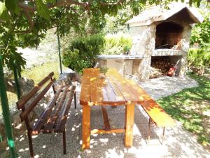 a wooden table and two chairs in front of a fireplace at House with large garden right next to the river in Žrnovnica