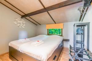 a bedroom with a bed with white sheets and a window at Cottage 213 in Sunparks Oostduinkerke with free parking and garden in Koksijde