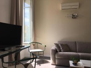 a living room with a couch and a tv at Palais Gioffredo place Massena in Nice