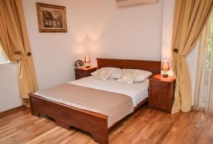 a bedroom with a bed with two night stands and two lamps at Apartments Petkovic Budva in Budva