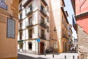 un edificio en una calle con gente caminando por la calle en Rosarioseis LOFT CORRAL DEL CARBÓN, en Granada