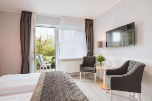 une chambre d'hôtel avec un lit, une table et des chaises dans l'établissement Hotel Schiffer, à Bensersiel