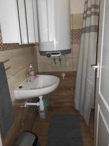 a bathroom with a white sink and a mirror at Szieszta Vendégház in Sárospatak