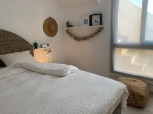 a bedroom with a white bed and a window at Penthouse Las 2 Salchichas in San Javier +23 photos