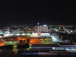 a city lit up at night with buildings and lights at Mirador Palace Hôtel in Chlef