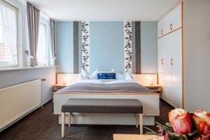 a bedroom with a bed and two windows at Hotel Schiffer in Bensersiel