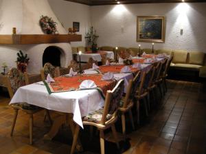 a room with a long table with chairs and a fireplace at Hotel Rhönhof in Oberleichtersbach