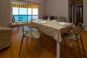 una sala da pranzo con tavolo e sedie e vista di Casa Baia Blu a San Lorenzo al Mare