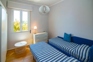 2 letti in una camera con finestra di Casa Baia Blu a San Lorenzo al Mare