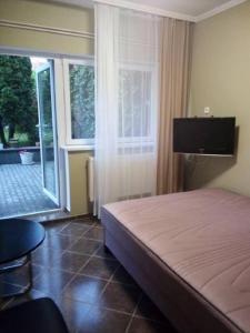 a bedroom with a bed and a large window at Apartman Ráchegy in Eger