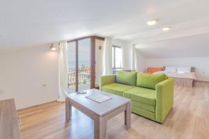 uma sala de estar com um sofá verde e uma mesa em Et Larum em Pestani