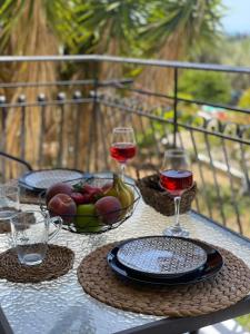 una mesa con dos copas de vino y un tazón de fruta en Lemon Tree Apartments B C, en Argostoli