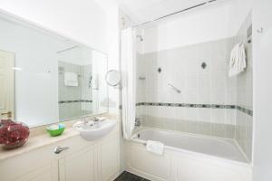 un bagno bianco con lavandino, vasca e lavandino di Killarney Lodge a Killarney Altre 19 foto
