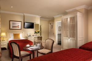 a hotel room with a bed and a table and chairs at Killarney Lodge in Killarney