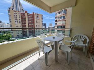 a balcony with a table and chairs and a view of a city at Apartamento Completo Torresol I in Benidorm +42 photos