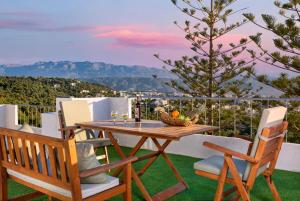 un tavolo e sedie su un balcone con vista di Sunset Home with sea view a Chania