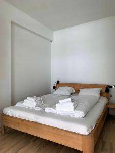 Una cama con sábanas blancas y toallas. en ApartmentInCopenhagen Apartment 358, en Copenhague