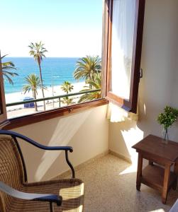 a room with a chair and a window with a view of the ocean at Hotel Maeva ,1 star B&B in Lloret de Mar