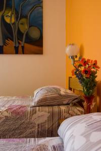 1 dormitorio con 1 cama y un jarrón de flores en Bed and Breakfast Ivanka Mali Lošinj en Mali Lošinj