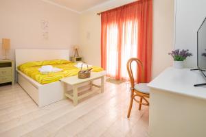 Schlafzimmer mit einem Bett, einem Tisch und einem Schreibtisch in der Unterkunft Sunset Home with sea view in Chania