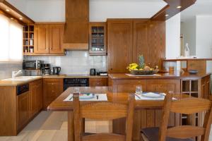 a kitchen with wooden cabinets and a wooden table and chairs at Sunset Home with sea view in Chania Town