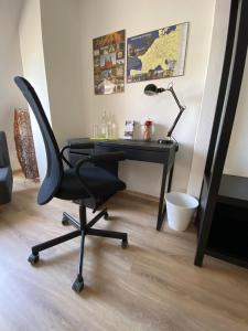 a desk with a chair and a lamp in a room at Ferienwohnung Am Jacobsweg in Wurzen
