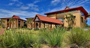 una casa con techo rojo en un campo de hierba en ANEW Hotel Ocean Reef Zinkwazi, en Zinkwazi Beach