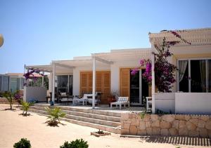 ein Haus am Strand mit einer Veranda in der Unterkunft Villa Cristina Alojamento, Praia de Chaves, Boa Vista, Cape Verde, WI-FI in Sal Rei