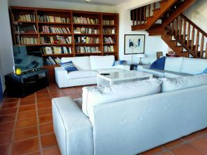 una sala de estar con sofás blancos y estanterías en Auténtica Casa Mediterránea con vistas al mar, en Santa Pola