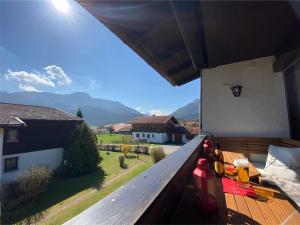 a balcony with a view of a house and mountains at AlpenKastl in Schleching