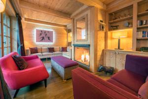salon z czerwonymi meblami i kominkiem w obiekcie Madame Vacances Chalet Davos w mieście Val dʼIsère