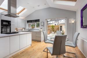 a kitchen with white cabinets and a table and chairs at Rothiemay House - Donnini Deluxe in Prestwick