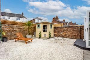 a backyard with a small yellow house and a table at Rothiemay House - Donnini Deluxe in Prestwick