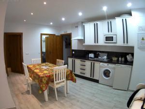 Apartamentos Turisticos Mirayuste في غوادالوبي: مطبخ مع طاولة ومطبخ مع حوض
