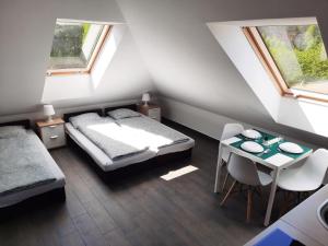 a bedroom with two beds and a table and two windows at Villa Eryka in Świnoujście