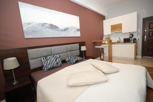 Coffee Apartments Espresso 6C في كراكوف: غرفة نوم بسرير ابيض كبير مع وسادتين