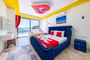 Schlafzimmer mit einem blauen Bett und roten Kissen in der Unterkunft Çınar 1-2 - 2 Bedroom with jacuzzi in Kalkan in Kaş + 18 Fotos