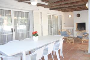 a patio with a white table and white chairs at Lovely villa next to the beach in Cambrils