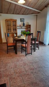 a dining room with a table and chairs on a tile floor at Schönermarker Pferdeparadies in Niederlandin