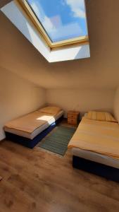 2 Betten in einem Zimmer mit Dachfenster in der Unterkunft Schönermarker Pferdeparadies in Niederlandin
